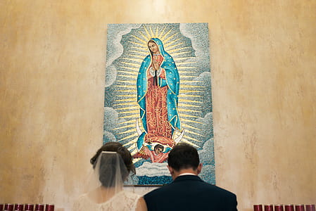 wedded couple kneeling in front of Our Lady of Guadalupe poster thumbnail