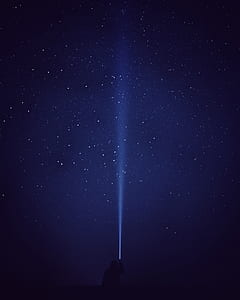 silhouette photograph of person holding flashlight under star thumbnail