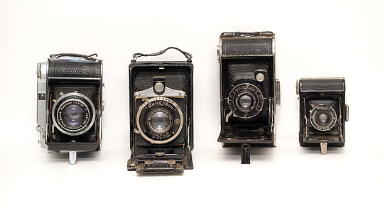 four black folding cameras on white surface thumbnail