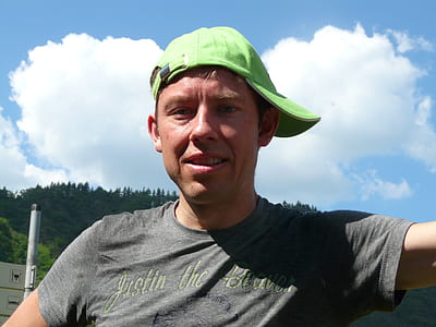 man in gray crew-neck t-shirt wearing green cap thumbnail