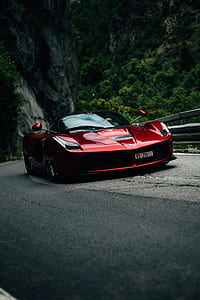 red Ferrari LaFerrari sports coupe on gray road thumbnail