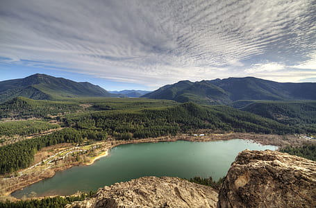 landscape photography of body water near mountains thumbnail