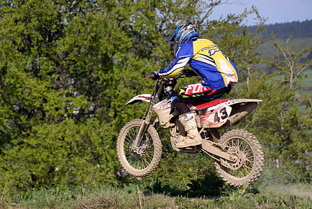man riding dirt bike on grass field thumbnail