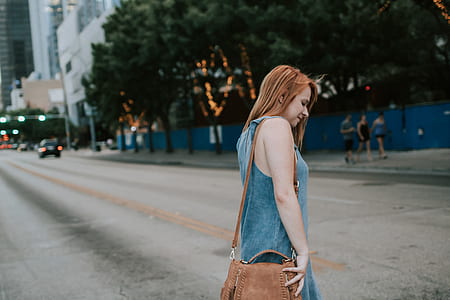 woman wearing blue denim sleeveless dress and brown leather 2-way bag at daytime thumbnail