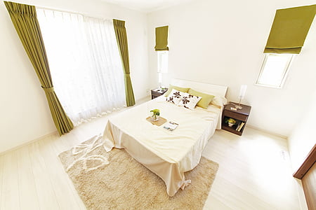 bed with headboard and beige comforter in room thumbnail