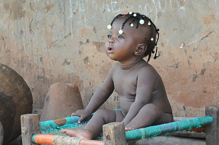 naked baby sitting on green frame thumbnail
