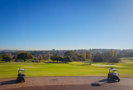 Two Golf Carts on Field Under Blue Sky thumbnail