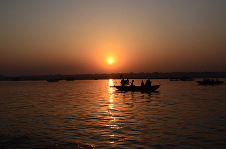 silhouette photo of boat on body of water thumbnail