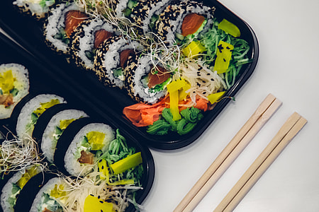 two brown wooden chopsticks near sushi thumbnail