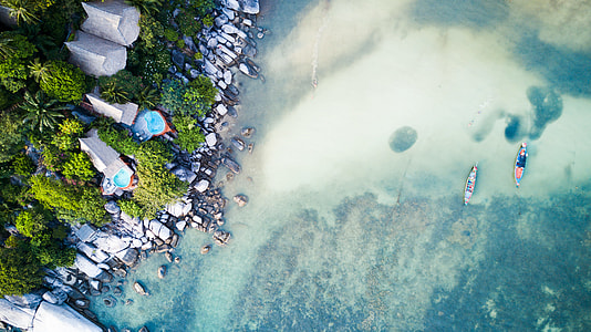 aerial photography of people riding boat and building near body of water during daytime thumbnail