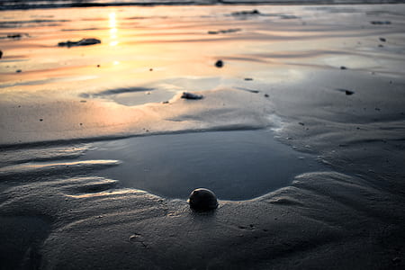 closeup photography of sand with water and stone thumbnail
