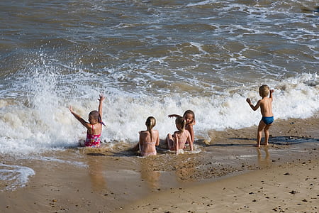 five children playing on seashore at daytime thumbnail