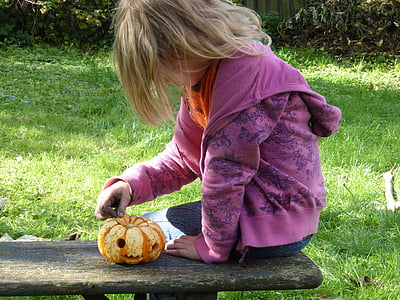 girl sitting on bench holding orange pumpkin thumbnail