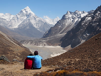 person sitting between mountain thumbnail