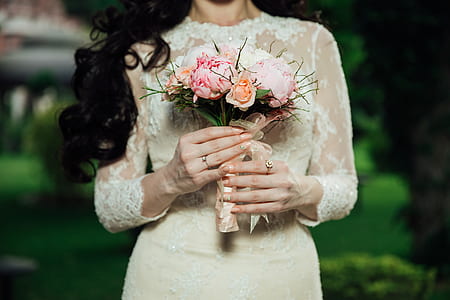 woman standing while holding pink petaled flowers bouquet thumbnail