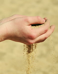 person holding brown sand at daytime thumbnail