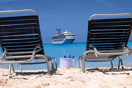 two empty outdoor lounges beside body of water with thumbnail