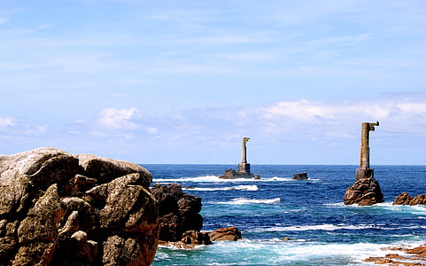rock formation in blue body of water at daytime thumbnail