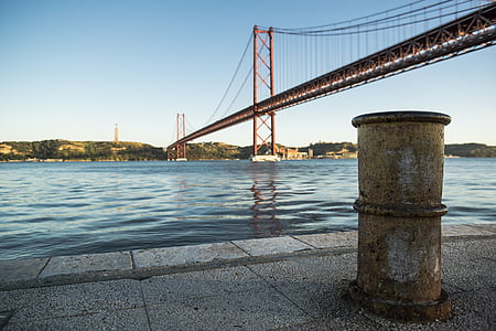 orange full-suspension bridge hanging on blue ocean water thumbnail