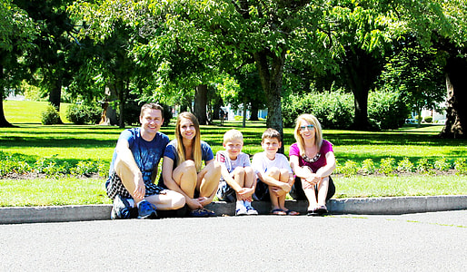 five people sitting on curb near trees thumbnail