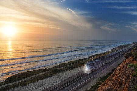 photo of white train near sea at noontime thumbnail