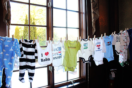 baby's assorted clothes in front of glass window during daytime thumbnail