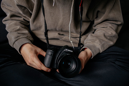 person holding Canon DSLR camera thumbnail