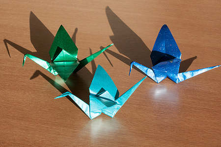 three blue and green origami on brown wooden table thumbnail