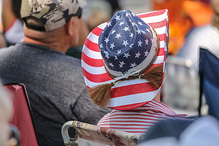 Woman watching a parade wearing a hat painted with American Flag pattern. thumbnail