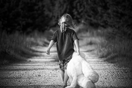 grayscale photo of girl wearing t-shirt holding teddy bear thumbnail