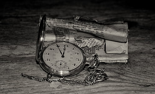round silver-colored pocket watch on table thumbnail