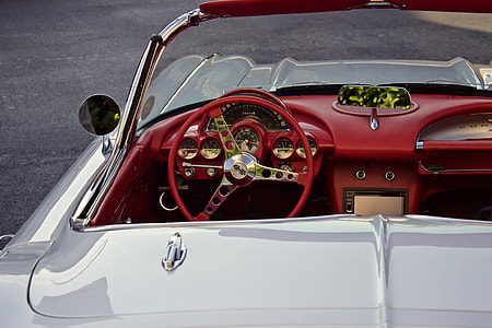 white convertible parked on black pavement thumbnail