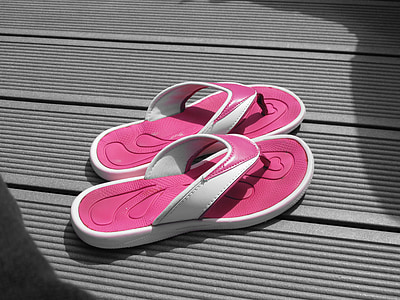 pair of pink-and-white flip-flops on floor thumbnail
