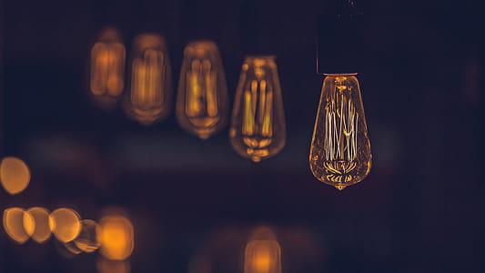 Close up of an Edison-style light bulb with several other such bulbs in the blurred background thumbnail