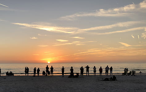 person taking photo of sunset scenery towards the ocean thumbnail