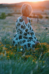 woman sitting on green grass during golden hour thumbnail