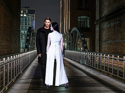 man standing on bridge with a woman in front of him thumbnail