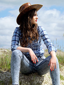 woman sitting on grass wearing brown hat under daytime thumbnail