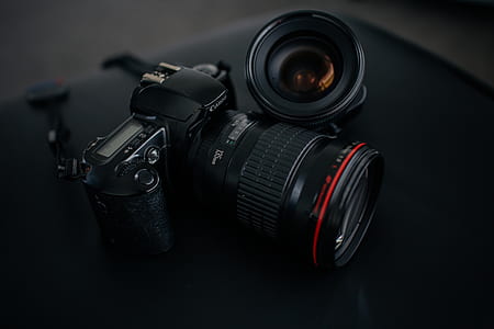 black camera lens leaning on DSLR camera thumbnail