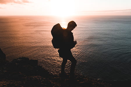 silhouette of person carrying bag at sunset thumbnail