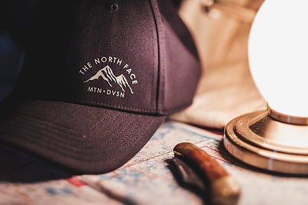 black The North Face cap beside brown straight razor thumbnail