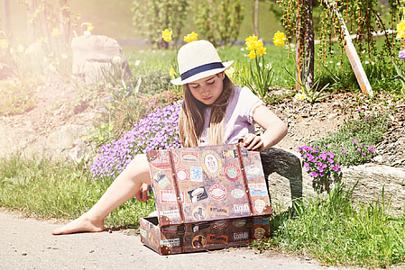 woman holding brown luggage on road thumbnail