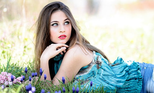 woman in teal sleeveless dress leaning on green grass thumbnail