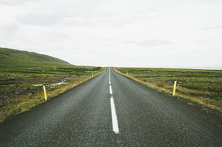 road surrounded by grass fields thumbnail