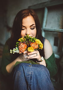 closeup photography of woman smelling bouquet of flowers thumbnail
