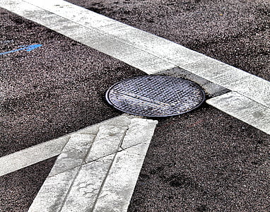 black metal manhole cover on street thumbnail