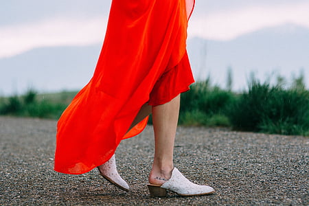 woman wearing red dress standing on gray pavement thumbnail