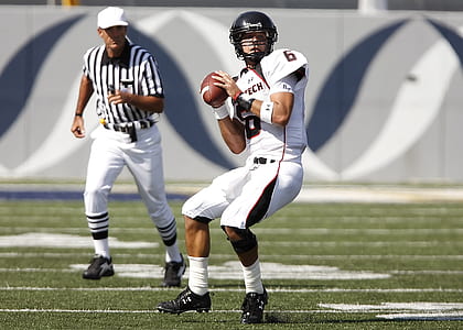 Football Playing Holding Football Near Referee thumbnail