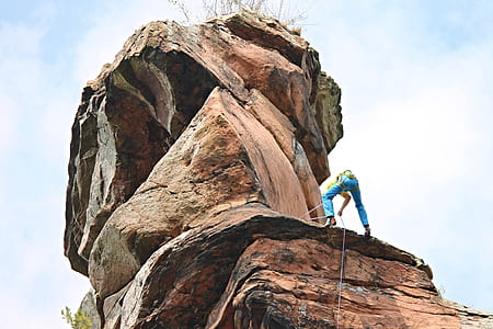 man climbing on brown mountain thumbnail
