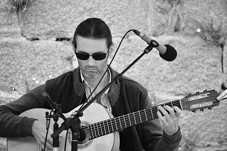 grayscale photo of a man playing guitar thumbnail